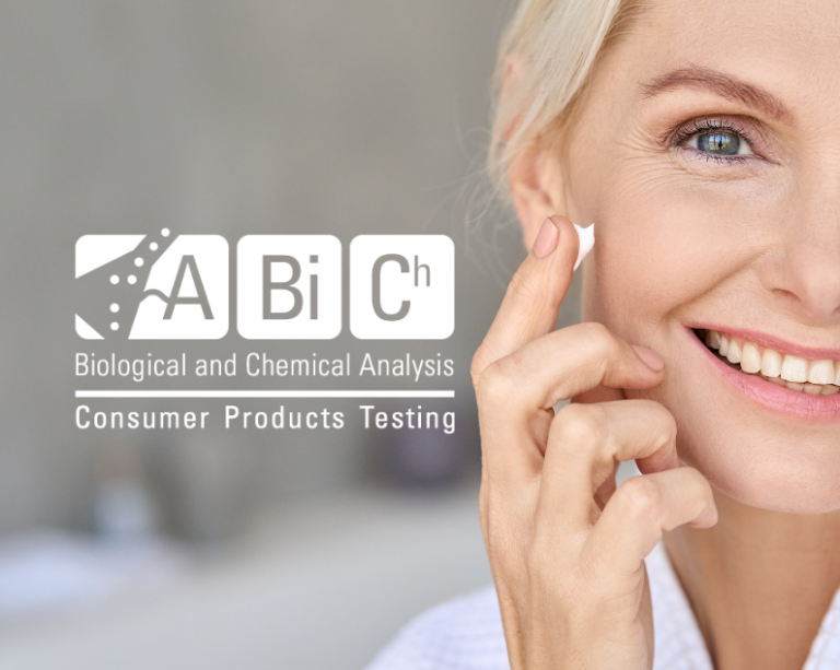 Smiling woman applying cream on her face.