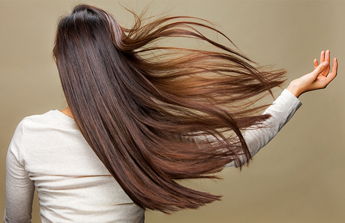 Woman with long, shiny hair, symbolizing the Lifeanalytics blog article on haircare product testing, cosmetic safety assessment, efficacy testing, claim substantiation, and scientific validation by the Cosmetic & Medical Device Business Unit